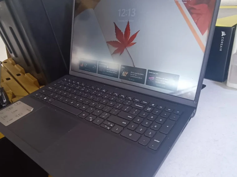 Misma laptop con la bisagra y la carcasa reparadas, encendida y funcionando en el escritorio