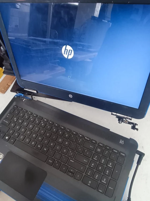 Bisagra de laptop HP expuesta con los tornillos de anclaje sueltos