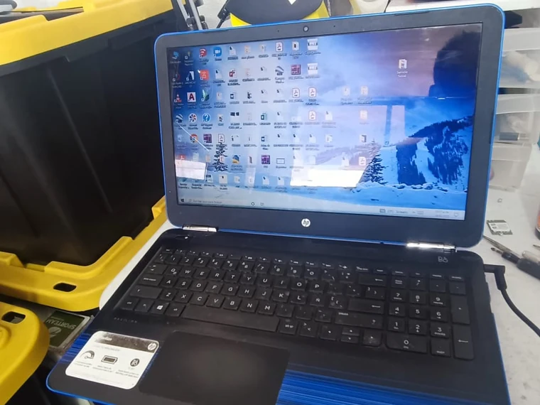 Misma laptop HP con la bisagra reparada, encendida y con el escritorio de Windows visible