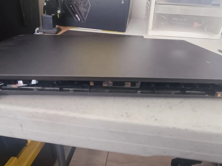Vista trasera de una laptop con el riel de la bisagra desmontado y expuesto