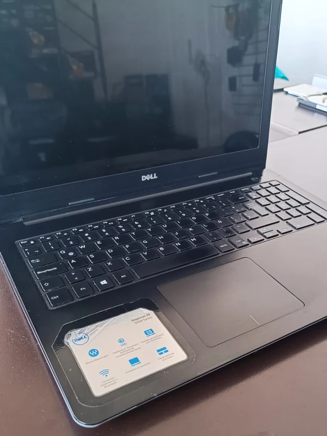 Misma laptop Dell Inspiron con la bisagra reparada, tapa cerrada y firme